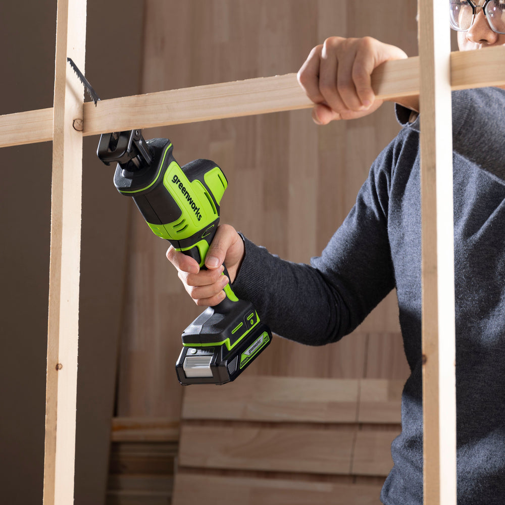 Person using a cordless drill to assemble wooden frames.